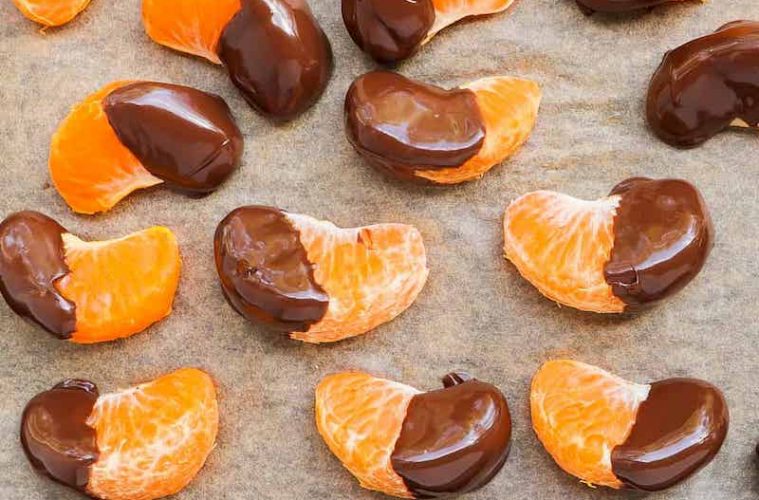 Gajos de mandarina madura bañados en chocolate con pimienta rosa