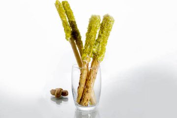 Palitos de pan con cobertura de queso y pistachos