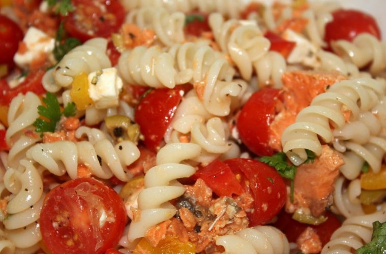Ensalada de pasta con salmón, tomate, mango, arándanos y frutos secos