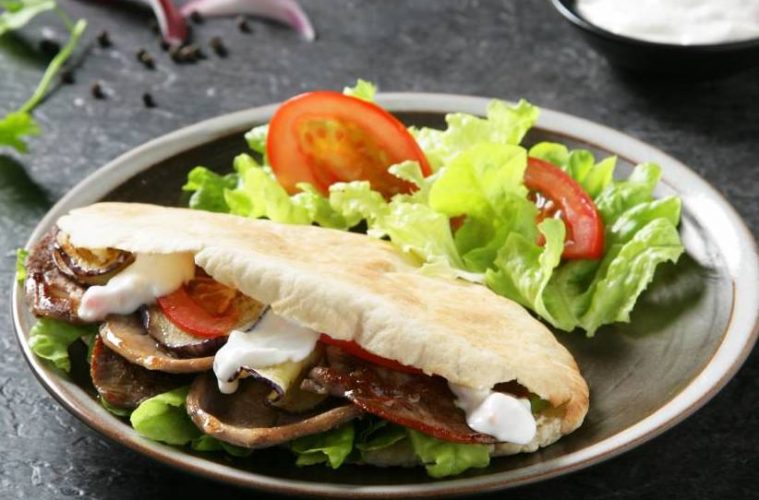 Pan de pita relleno de berenjena, cordero y salsa de yogur