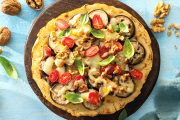 Pizza de harina de garbanzos con verduras, nueces y cebolla caramelizada