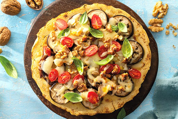 Pizza de harina de garbanzos con verduras, nueces y cebolla caramelizada