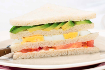 Sándwich de aguacate, huevo duro, mayonesa y tomate que empieza a madurar